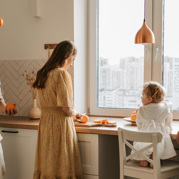 famiglia in cucina luminosa, mamma e papà cucinano per i bambini giocando