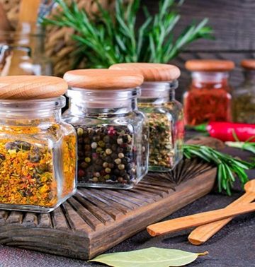 Spezie macinate in contenitori etichettati su uno scaffale in cucina
