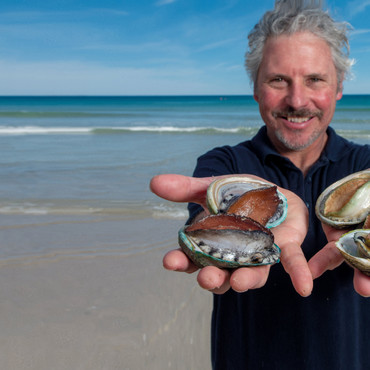 Pescatore con il so pescato e il mare alle spalle