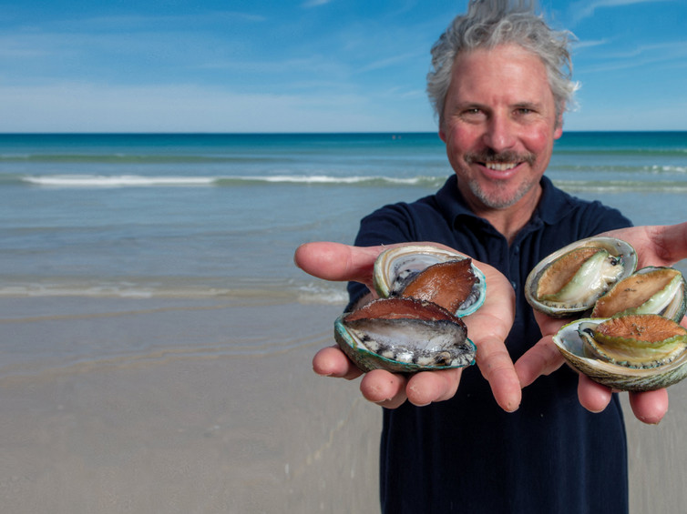 Pescatore con il so pescato e il mare alle spalle