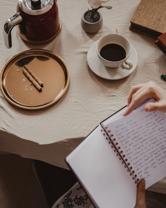 tavolo con quaderno e caffè